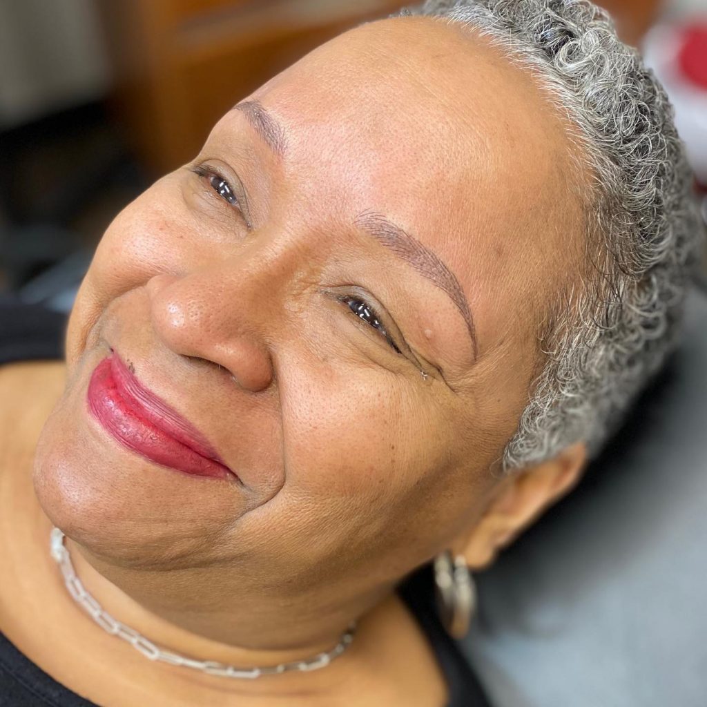 A woman with gray hair smiling at the camera.